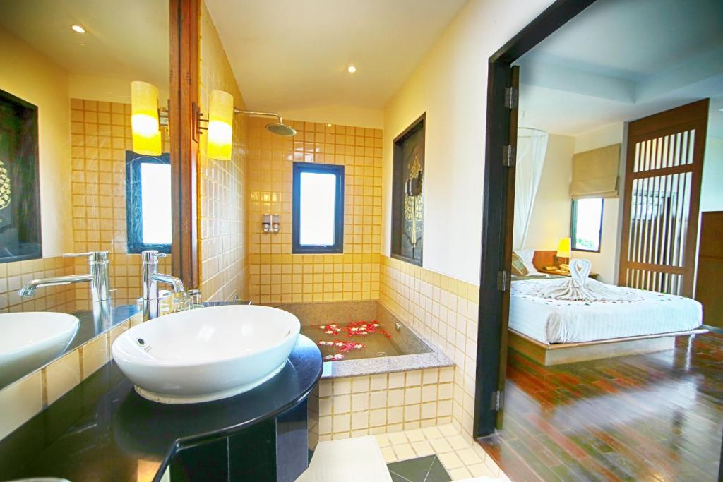 a bathroom with a tub and a sink and a bath tub at Supalai Scenic Bay Resort And Spa, SHA Extra Plus in Por Bay