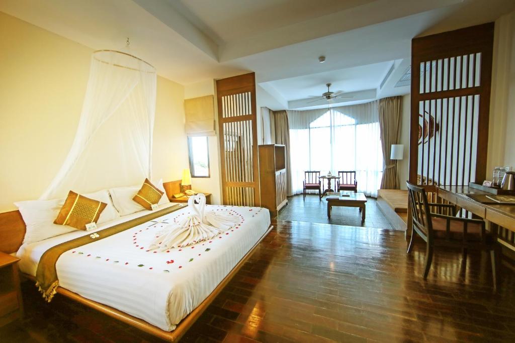 a hotel room with a large bed and a desk at Supalai Scenic Bay Resort And Spa, SHA Extra Plus in Por Bay