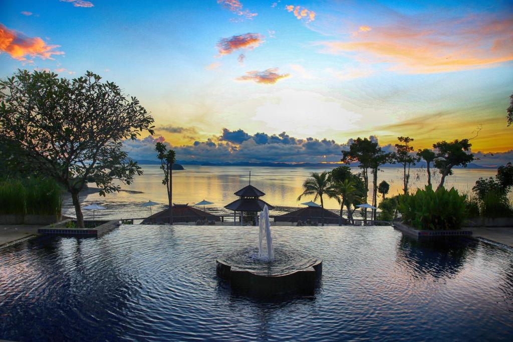 a pool with a fountain in the middle of a resort at Supalai Scenic Bay Resort And Spa, SHA Extra Plus in Por Bay