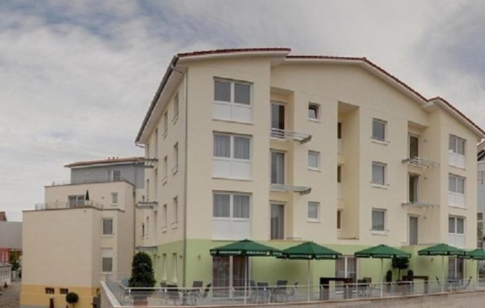 a large building with green umbrellas in front of it at BusinessHotel Schramberg in Schramberg