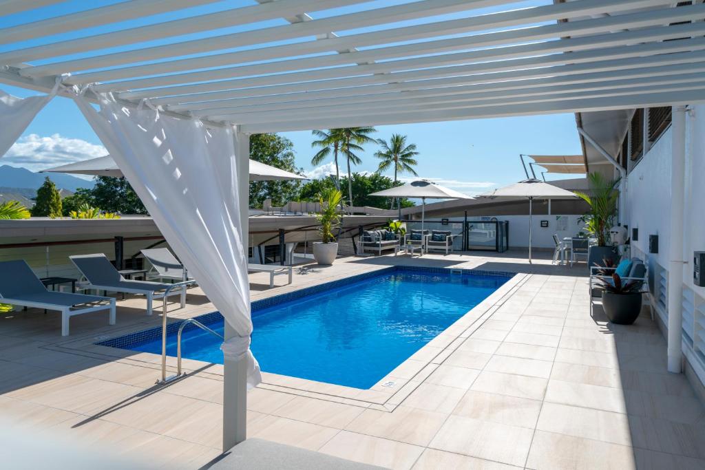 a white pergola over a swimming pool on a house at Saltwater Luxury Apartments in Port Douglas