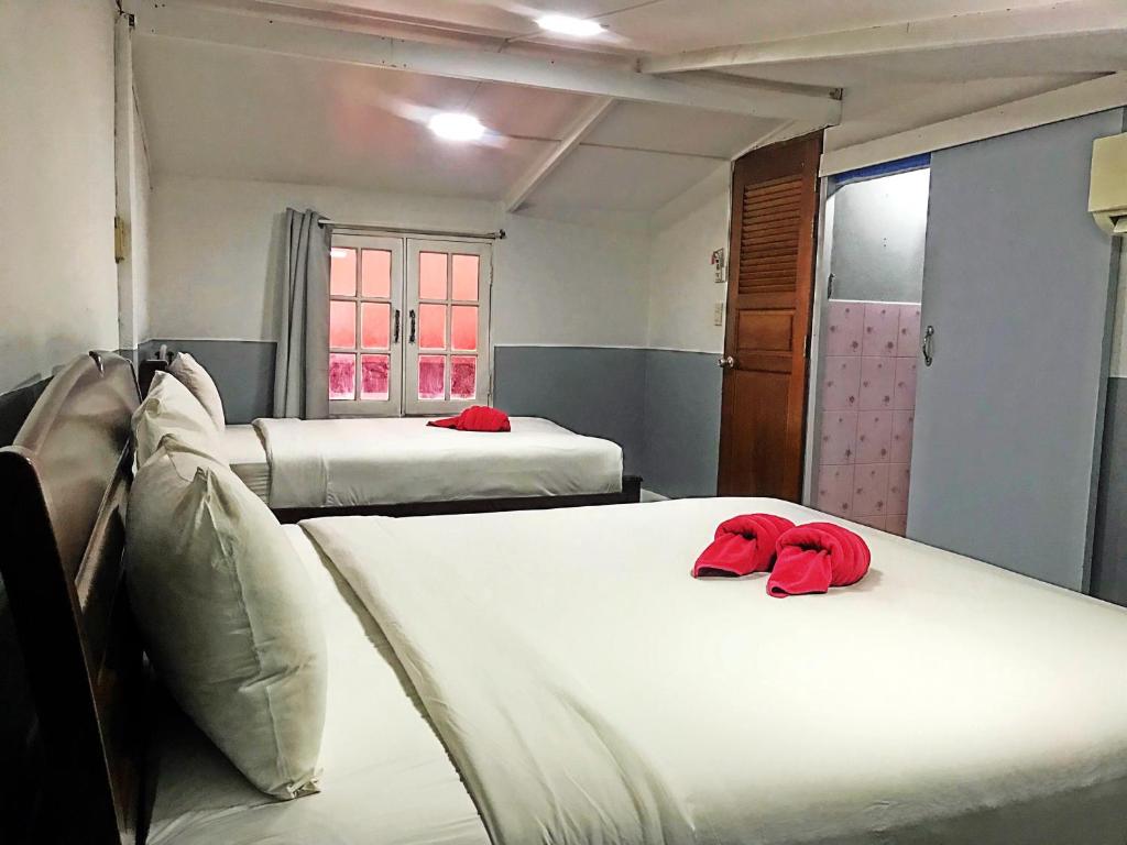 two beds in a room with red pillows on them at Red Samed Party House in Ko Samed