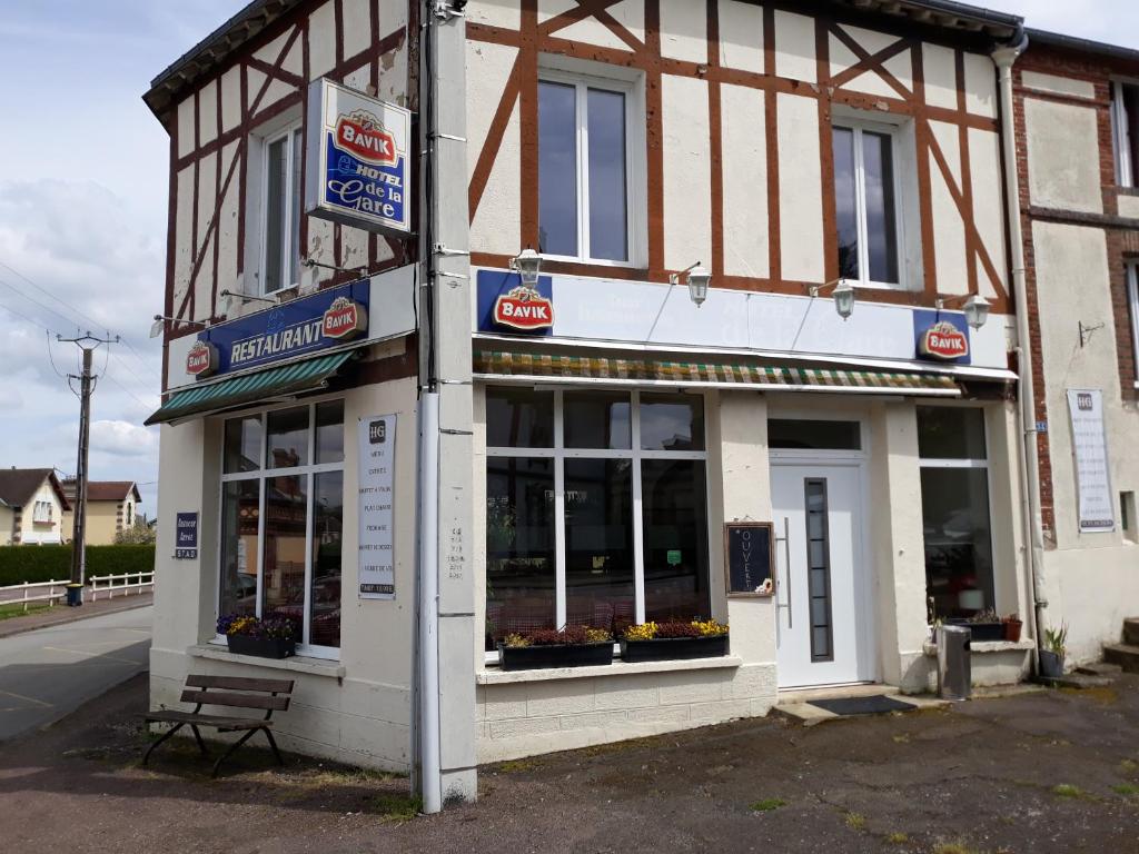 a store front of a building with a bench in front at Hotel De La Gare in Sainte-Gauburge-Sainte-Colombe