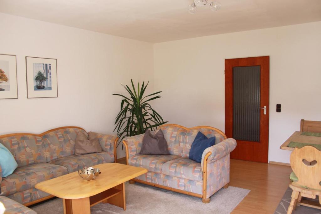 ein Wohnzimmer mit 2 Sofas und einem Tisch in der Unterkunft Apartments Eichenweg in Rednitzhembach