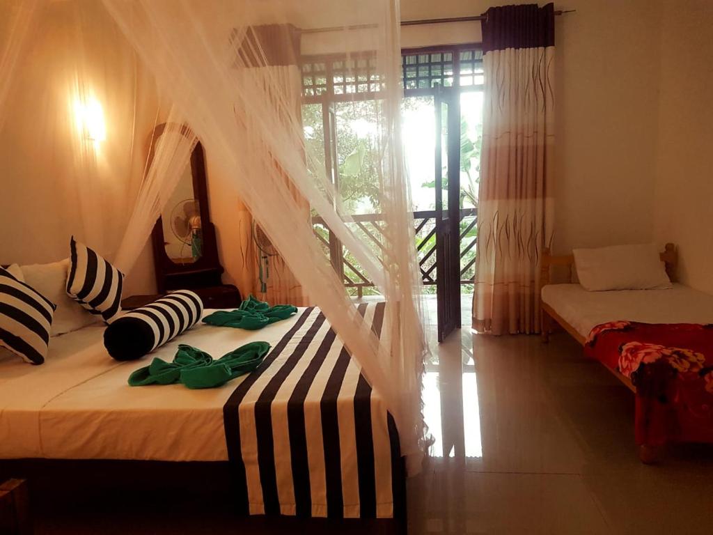 a bedroom with two beds with a mosquito net at Red Rose Ella in Ella