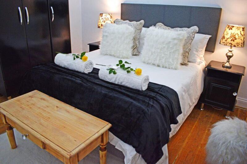 a bedroom with a large bed with towels on it at FlowerBox Cottages in Mossel Bay