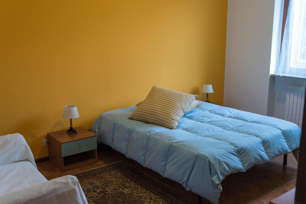 a bedroom with a blue bed with a pillow on it at Luminoso bilocale in Alessandria