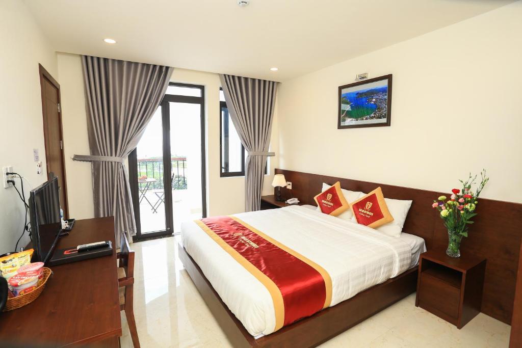 a hotel room with a bed and a television at Hacom Galaxy Hotel in Phan Rang–Tháp Chàm