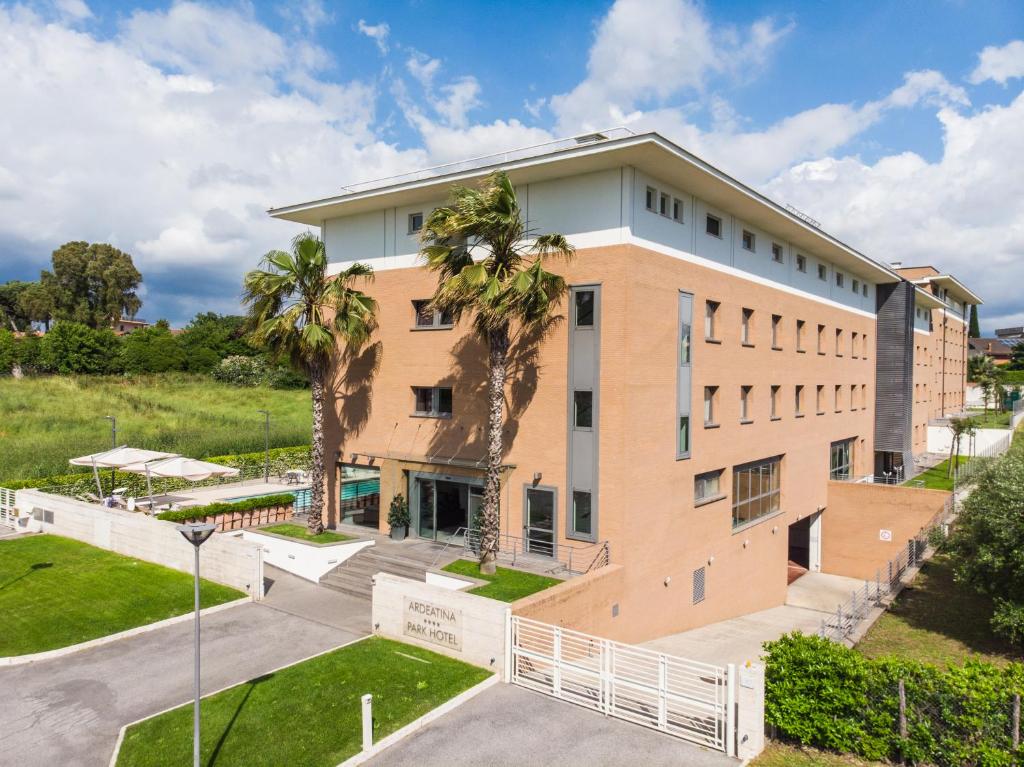 un edificio de oficinas con palmeras delante en Ardeatina Park Hotel, en Castel di Leva