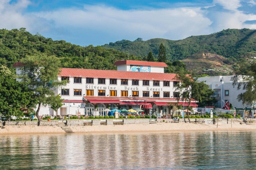 a building on the beach next to a body of water at Silvermine Beach Resort in Hong Kong
