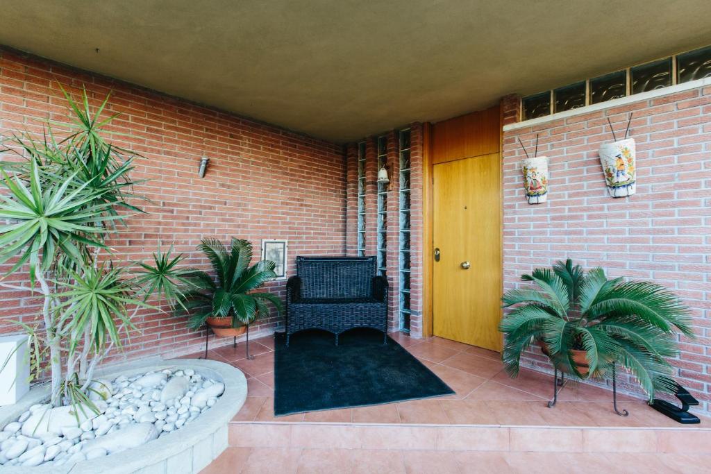 a patio with a chair and plants on a brick wall at Mi Refugio in Alicante