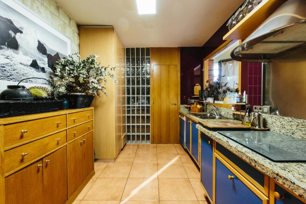 a kitchen with wooden cabinets and blue counters at Mi Refugio in Alicante