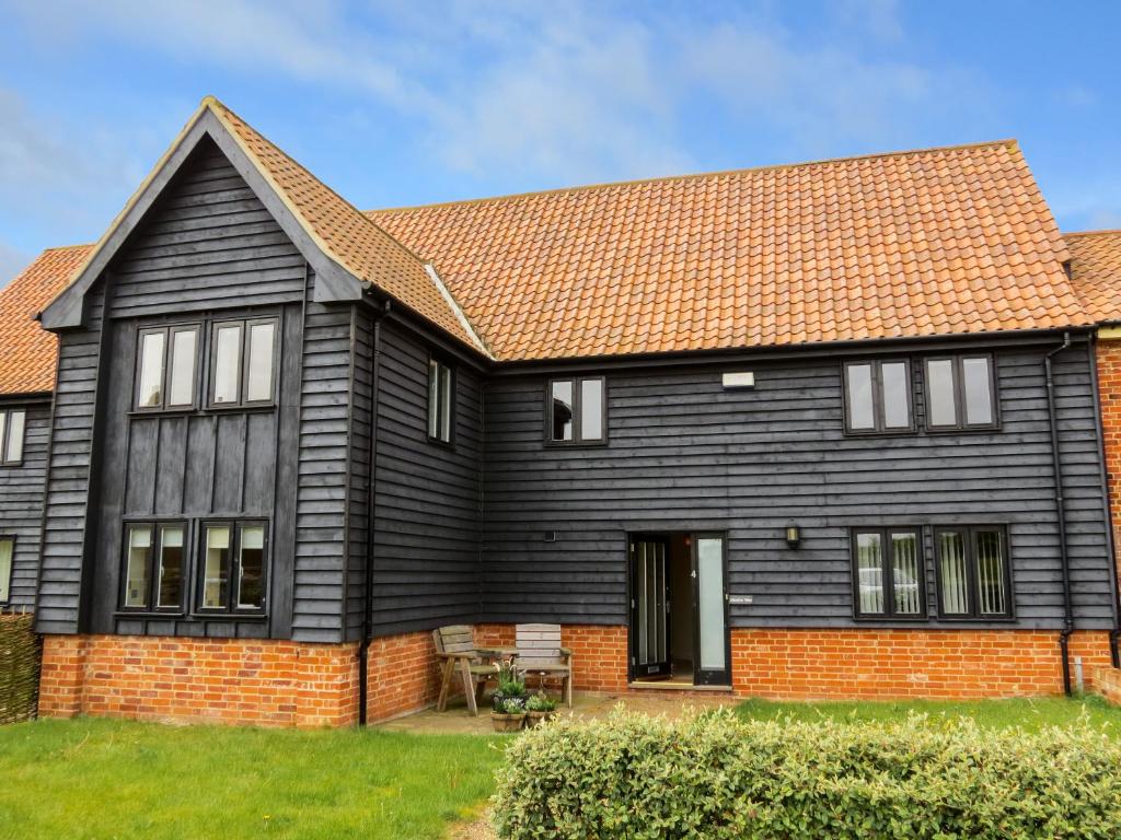 a black house with a red brick at Meadow View, Near Aldeburgh in Aldringham