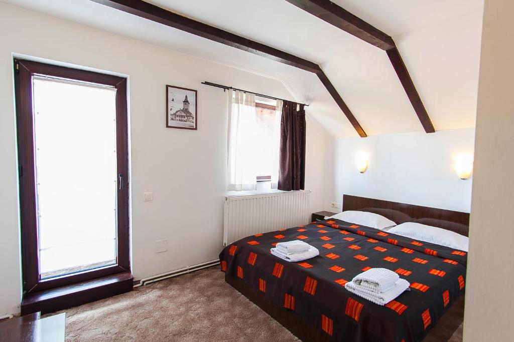 a bedroom with a bed and a large window at Casa Thomas Bran in Bran