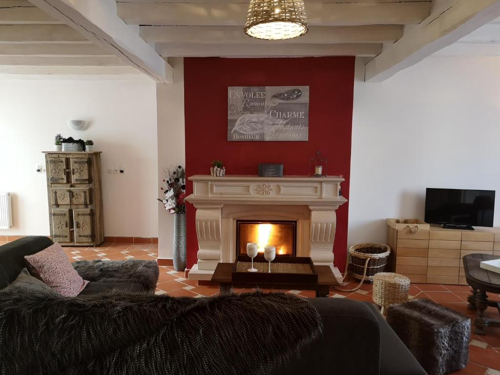 ein Wohnzimmer mit Kamin und Couch in der Unterkunft la Maison de Lilly in Pierry