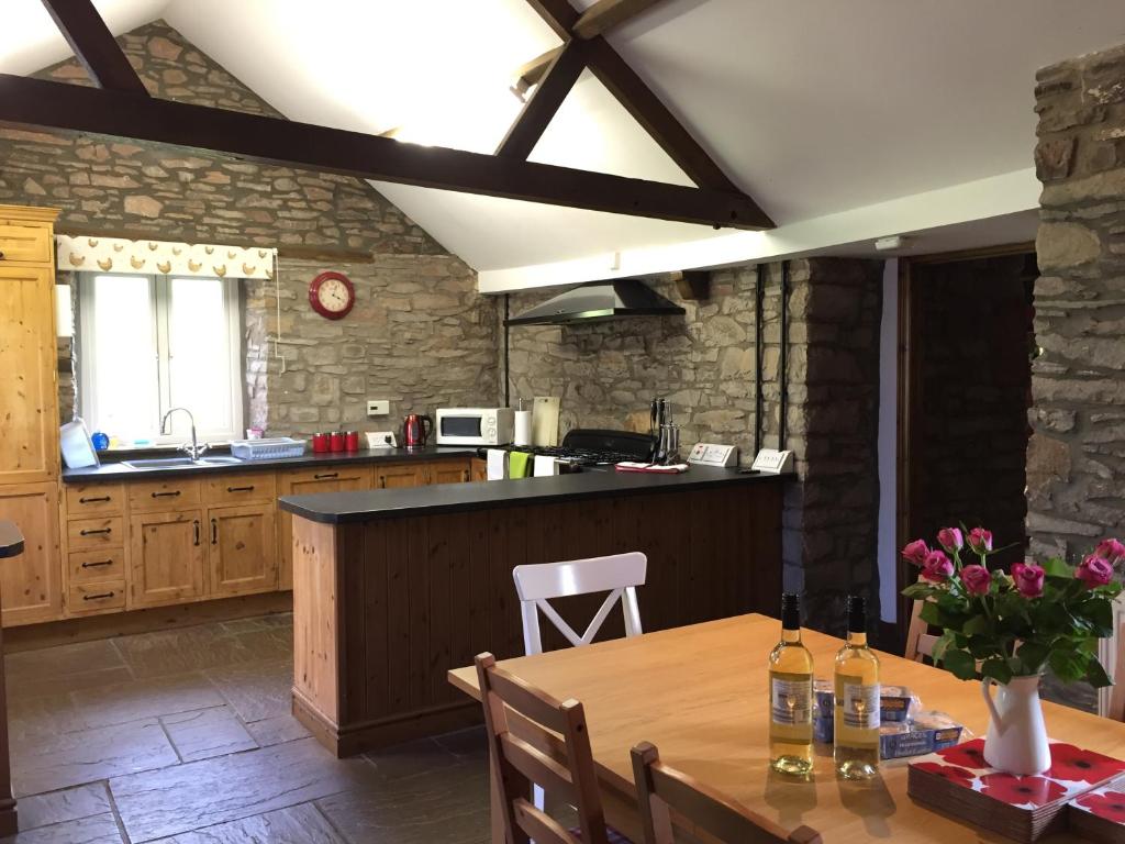 a kitchen with a wooden table and a counter top at Llwyn Llwyd Cottage in Brecon
