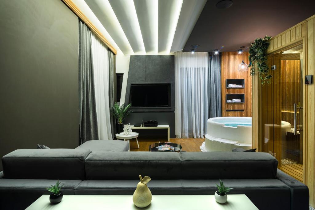 een woonkamer met een bank, een tv en een bad bij Little Dubai in Belgrado