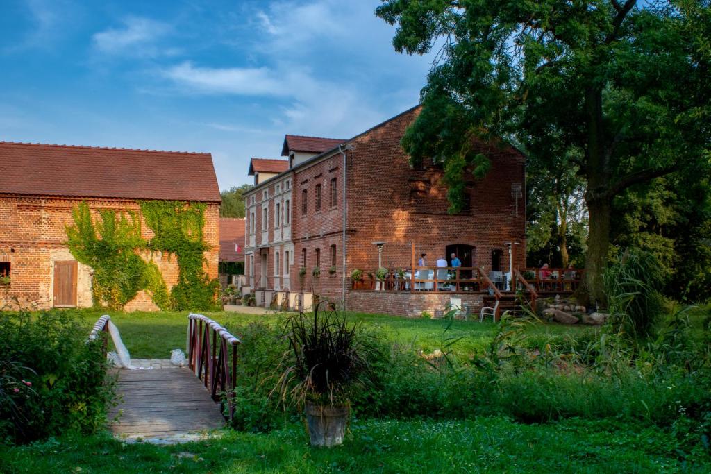 a brick building with a wooden walkway in front of it at Leniwka in Świebodzin