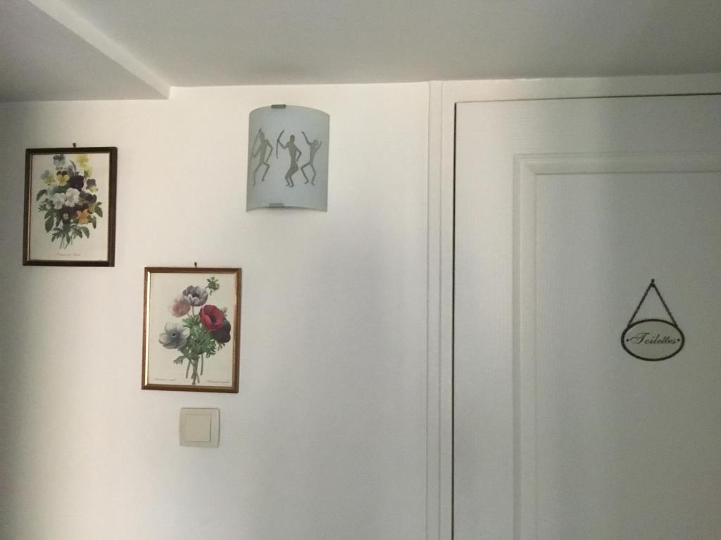 a room with three pictures on the wall and a door at Aux Cornettes in Beaune