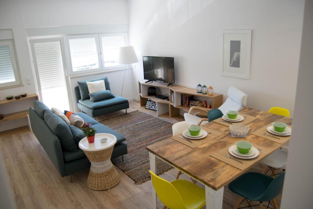 ポルティマンにあるFantástico apartamento a 200m da Praiaのリビングルーム(木製テーブル、椅子付)