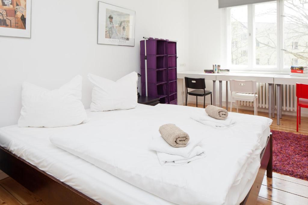 a bedroom with a large white bed with two towels on it at Schloss Apartment in Berlin