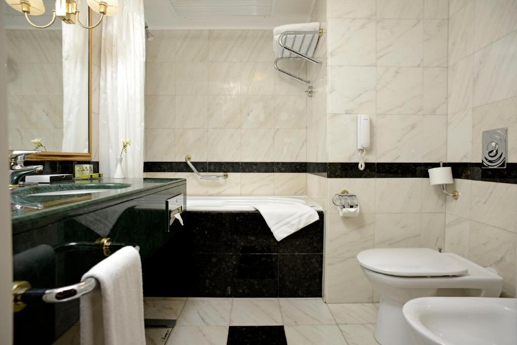 a bathroom with a toilet and a sink at Grand Hotel Bucharest in Bucharest