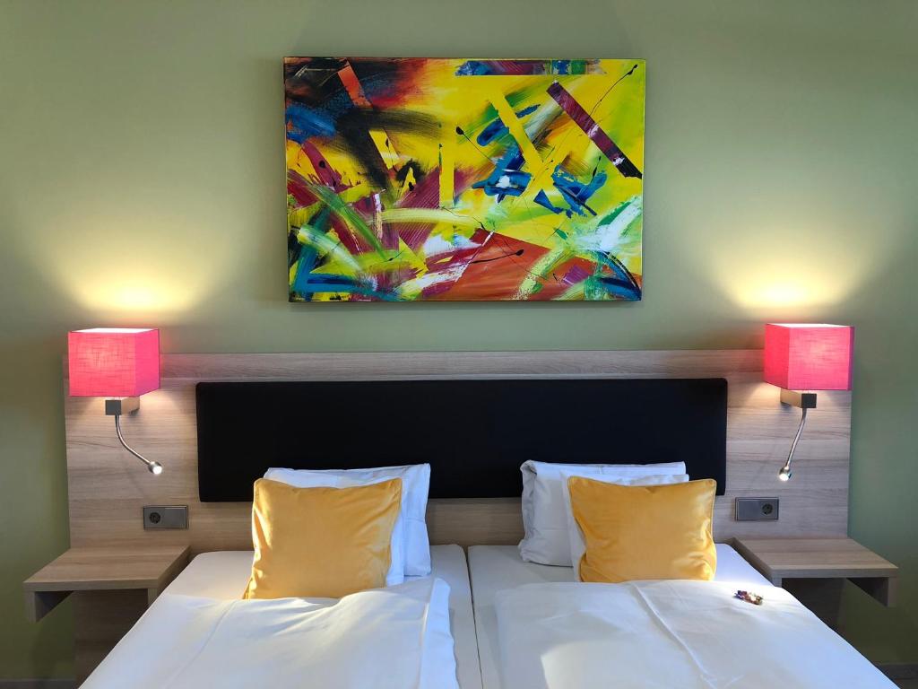 a bedroom with two beds and a painting on the wall at Hotel „Zur Linde“ in Ehingen