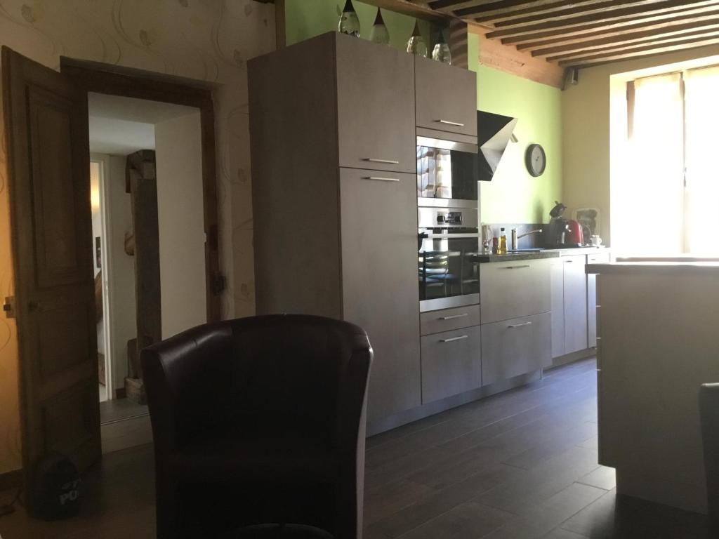 a kitchen with a black chair in a room at Aux Cornettes in Beaune