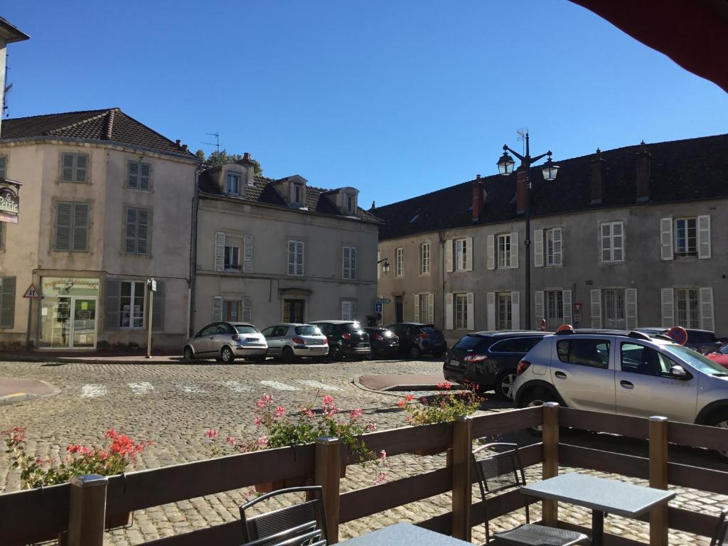 a row of buildings with cars parked in a parking lot at Aux Cornettes in Beaune