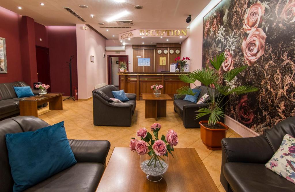 a waiting room with couches and flowers on the wall at Plaza Hotel in Varna City