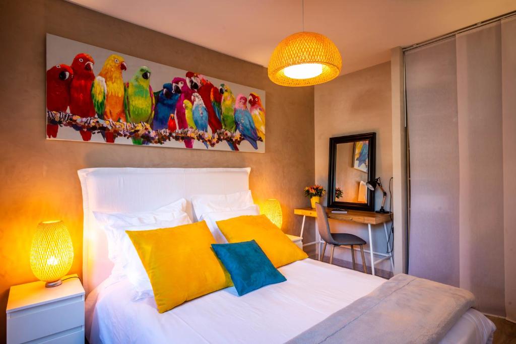 ein Schlafzimmer mit einem weißen Bett und gelben Kissen in der Unterkunft LE CHATELET- Parking Gratuit - Cosy et Design - à 10 mn de Geneve in Annemasse