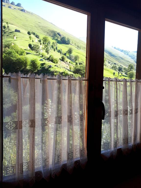 ein Fenster mit Blick auf einen grünen Hügel in der Unterkunft Posada La Vieja Escuela in San Roque de Ríomiera