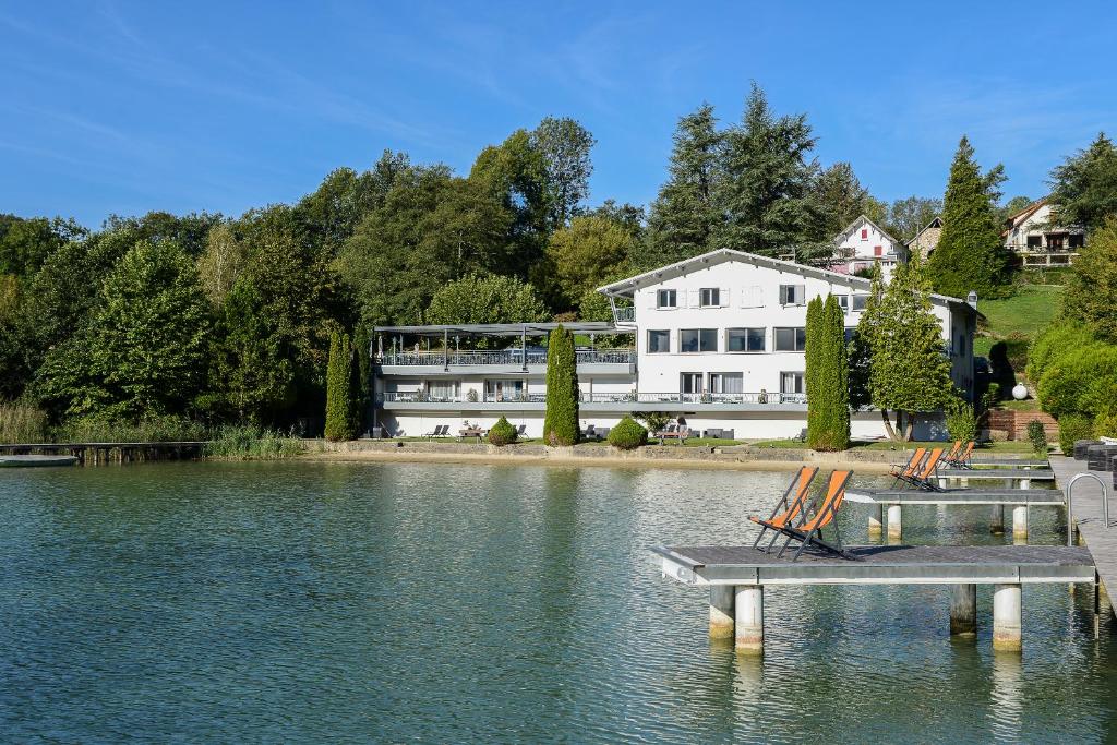 una casa con un muelle en medio de un lago en Novalaise Plage, en Novalaise