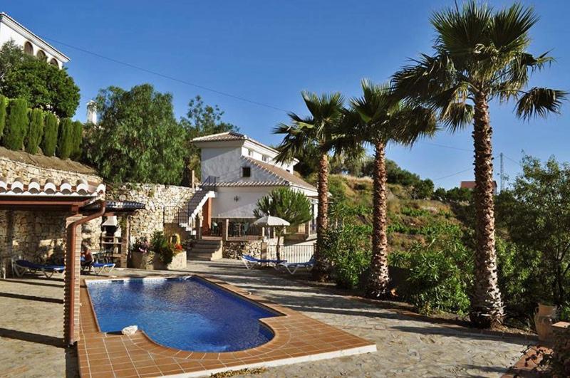 uma casa com piscina e palmeiras em Finca Maroma em Cómpeta