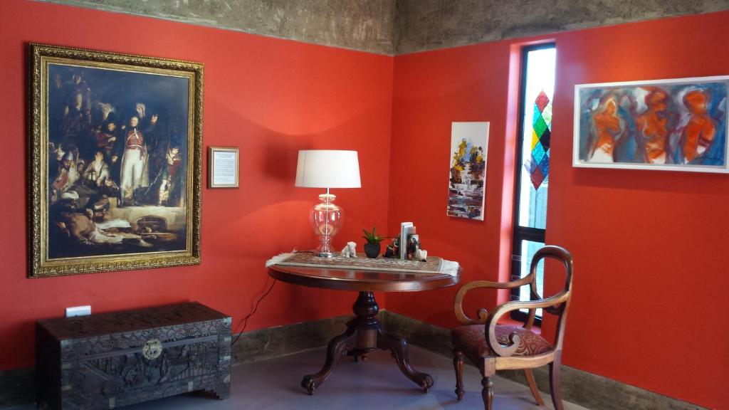 una habitación roja con una mesa con una lámpara. en Absolute Castillo, en Riebeek-Kasteel