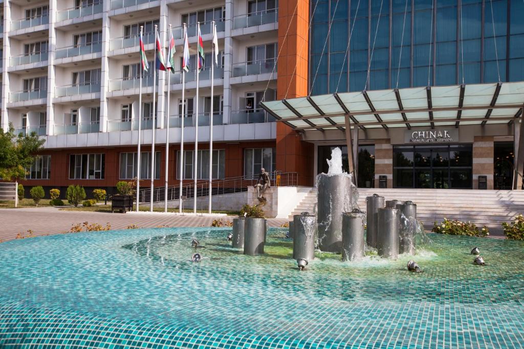 a fountain in the water in front of a building at Chinar Hotel & Spa Naftalan in Naftalan