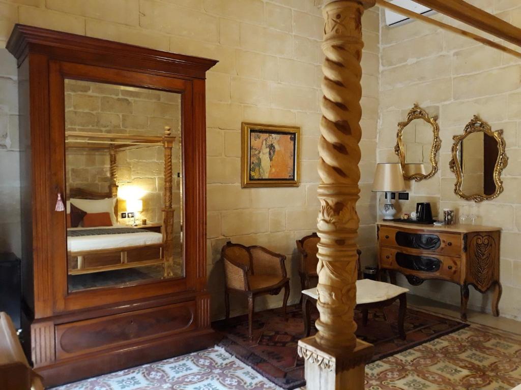 a room with a mirror and a table and a bed at The 3Cities Auberge in Cospicua