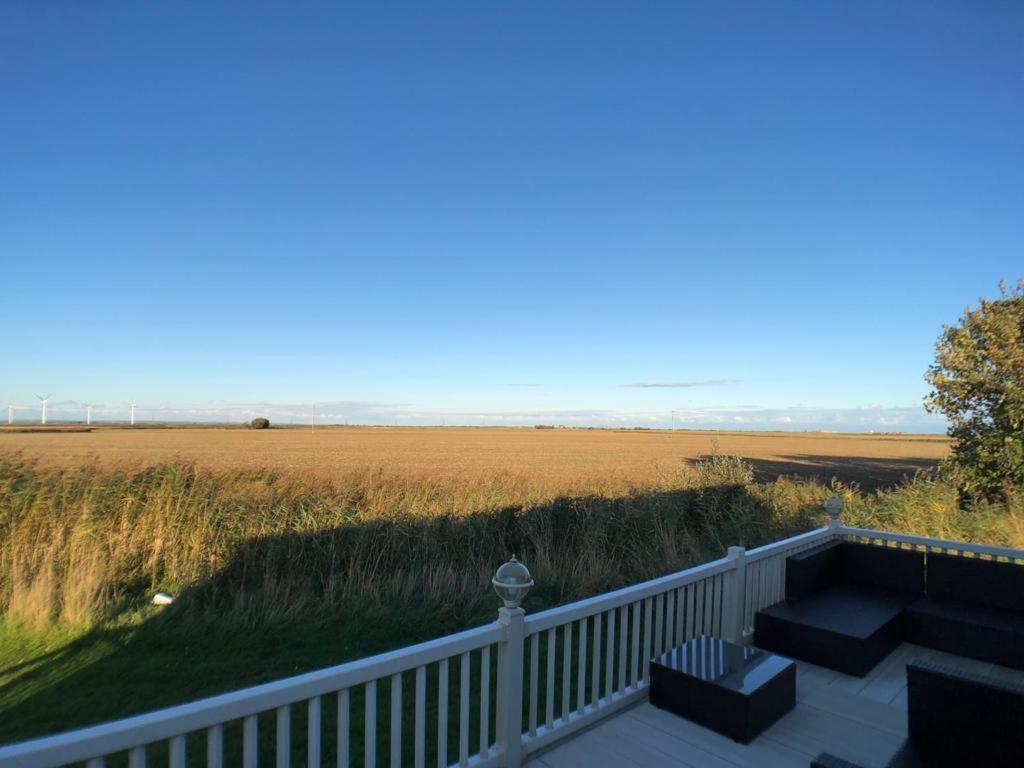 uma varanda com vista para um campo de relva em Camber coast holidays em Camber