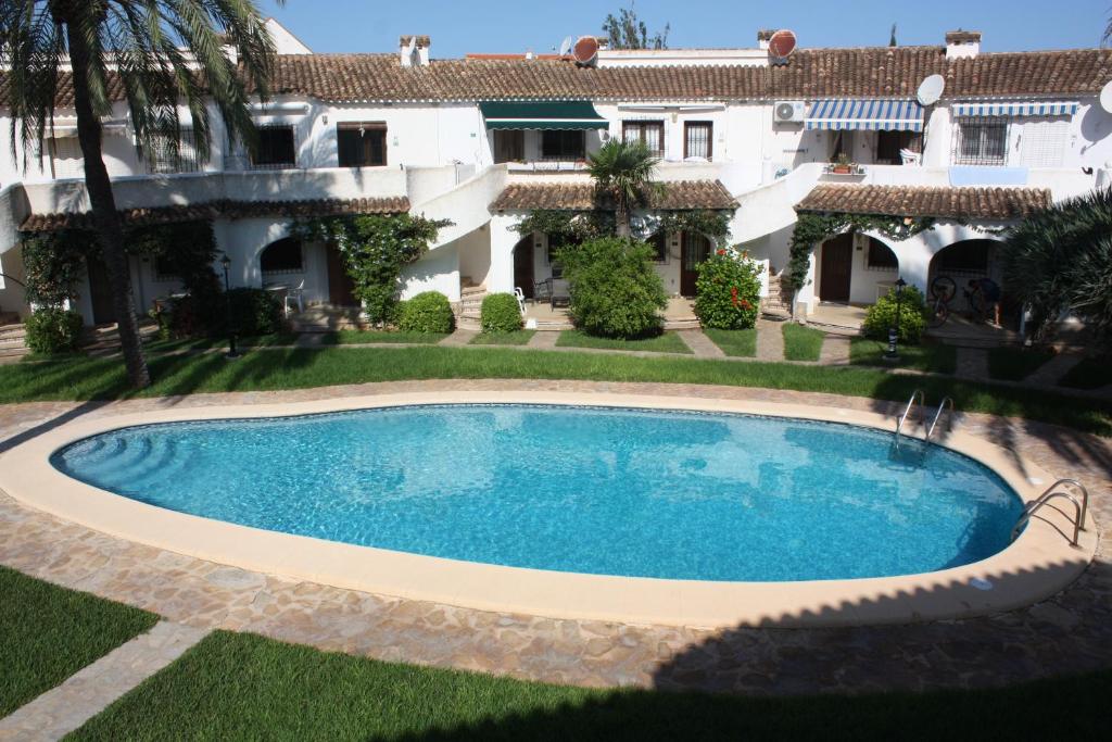 a swimming pool in front of a house at Apartamento Oasis Park in Denia