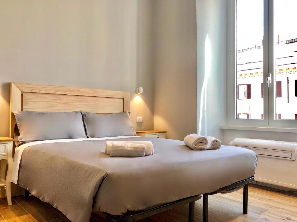 een slaapkamer met een bed met twee handdoeken erop bij Audrey's Roman Holidays - Rome Suites & Rooms in Rome