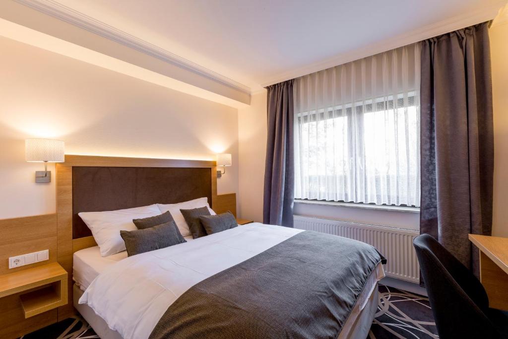 a hotel room with a bed and a window at Hotel Lang in Breidenbach