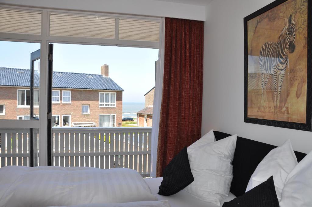1 dormitorio con cama y ventana grande en Schelvis Apartments, en Zandvoort