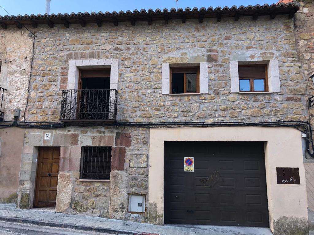 西古恩薩的住宿－Casa Rural El Tinte，一座石头建筑,设有两个车库门和窗户