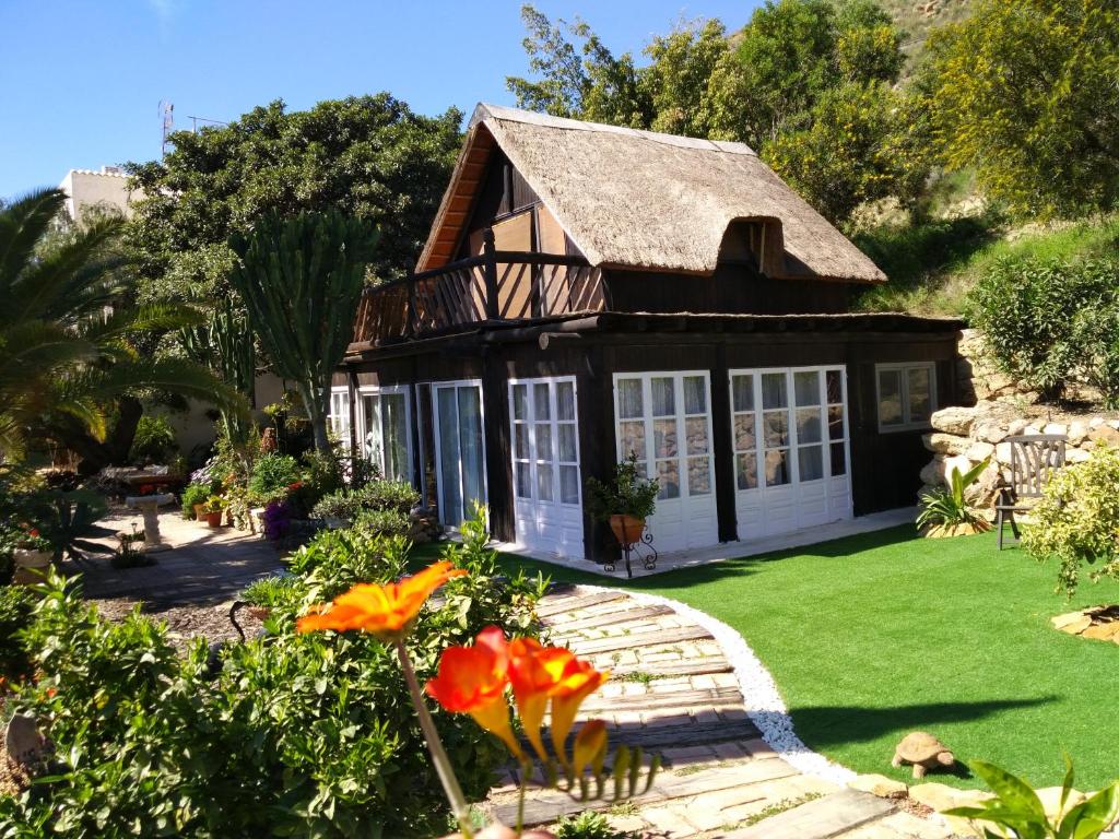 una pequeña casa con un patio verde con flores en El Jardín de las Hadas, en Turre