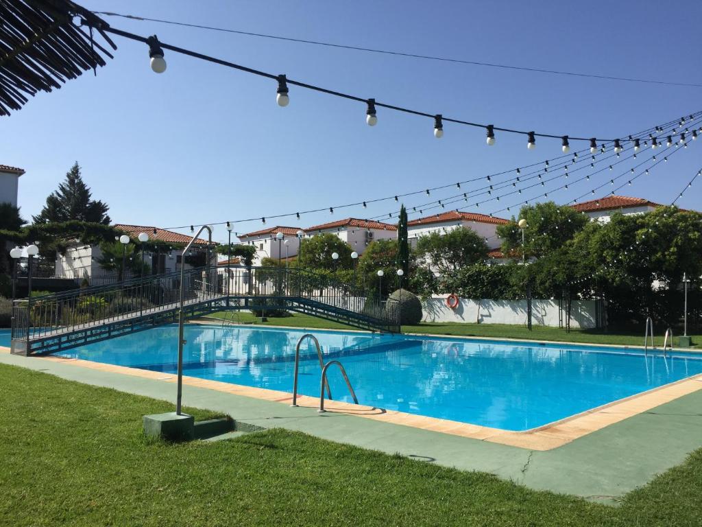 uma grande piscina azul com uma ponte em Apartamentos Atalayas Extremadura em Zafra