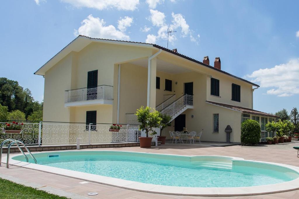 a villa with a swimming pool in front of a house at Casa Vacanze La Mattonara in Viterbo