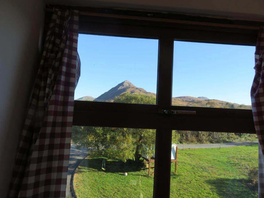 a window with a view of a mountain at Letterfrack Mountain Farm Cottage on farm in village centre in Letterfrack