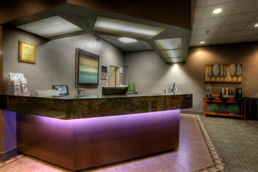 a hotel lobby with a reception counter with purple lighting at Royal Hotel Lloydminster in Lloydminster