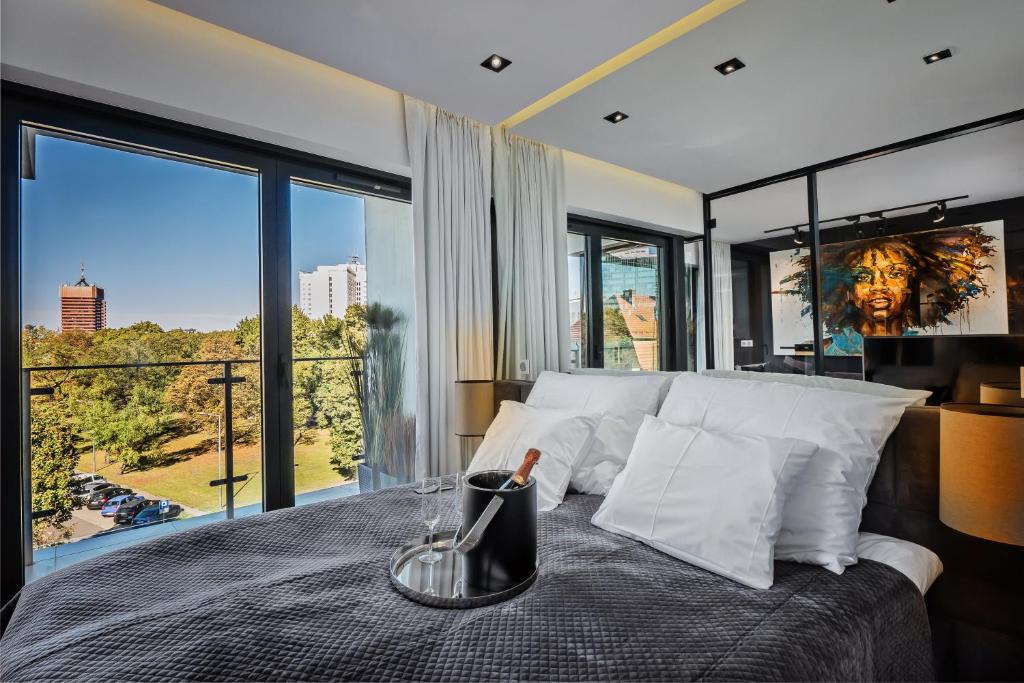 a bedroom with a large bed with a large window at Andersia Park in Poznań