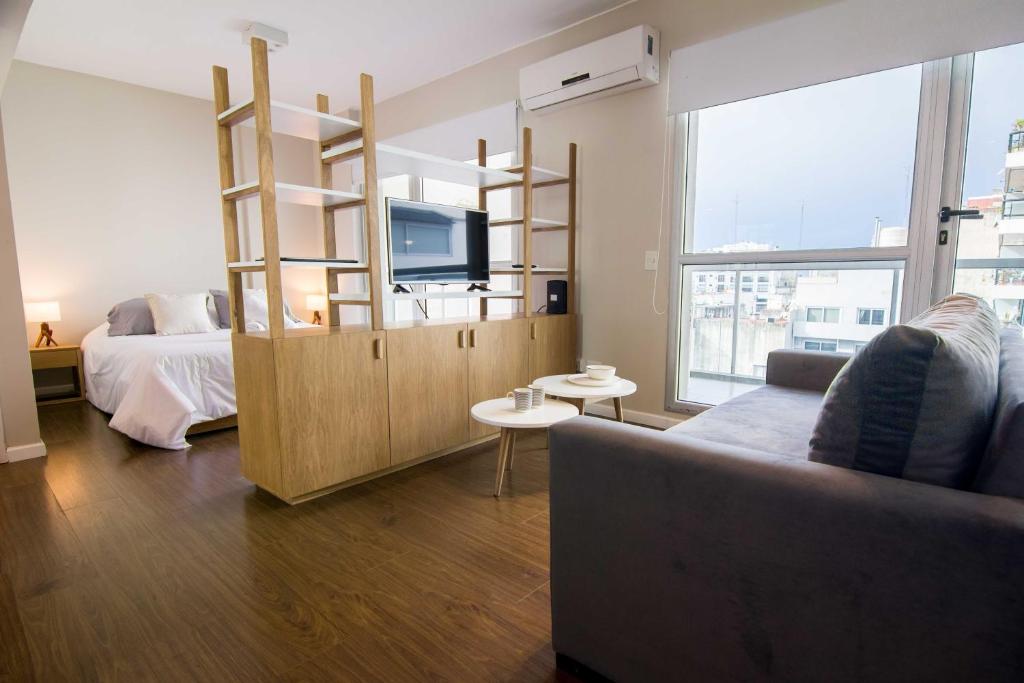 a living room with a couch and a tv and a bed at High End Studio in Central Recoleta -12J- in Buenos Aires